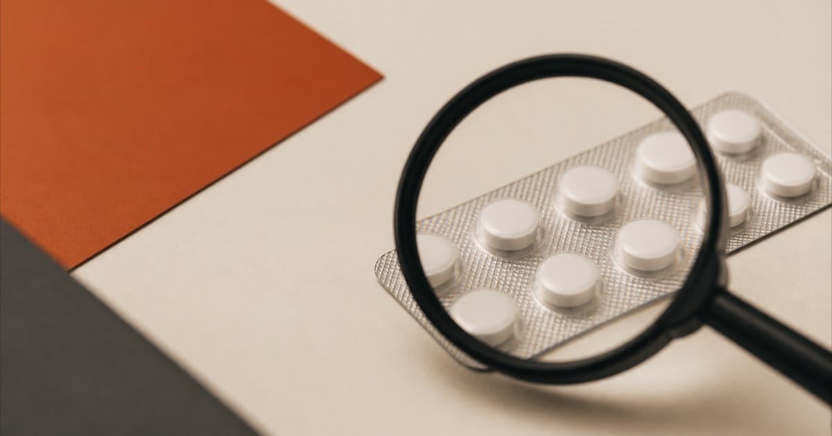 A magnifying glass held over a blister pack of pills