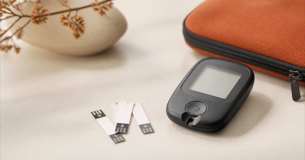 A glucose meter and test strips on a table